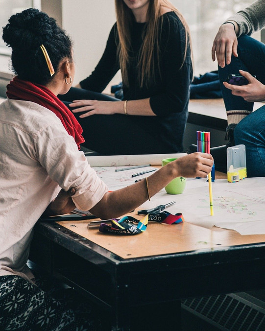 Gruppe von Studierenden mit Arbeitsmaterialien
