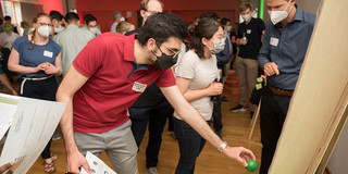 A person passes a ball to vote for a poster