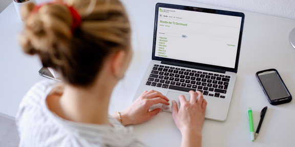 Photo of a woman looking at a laptop