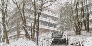 A snow-covered staircase leading to the EF50 building of TU Dortmund.