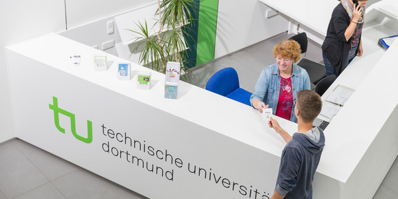 Ein Student gibt seine Wartenummer bei der Studienberatung ab.