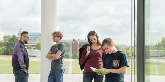 Studierende im Gespräch vor einem Fenster