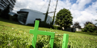 TU logo In the foreground one can see the green TU logo on the grass and in the background there is the Mathetower.