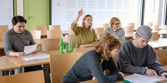 Studierende Handmeldung Studierende im Seminarraum sitzen am Tisch